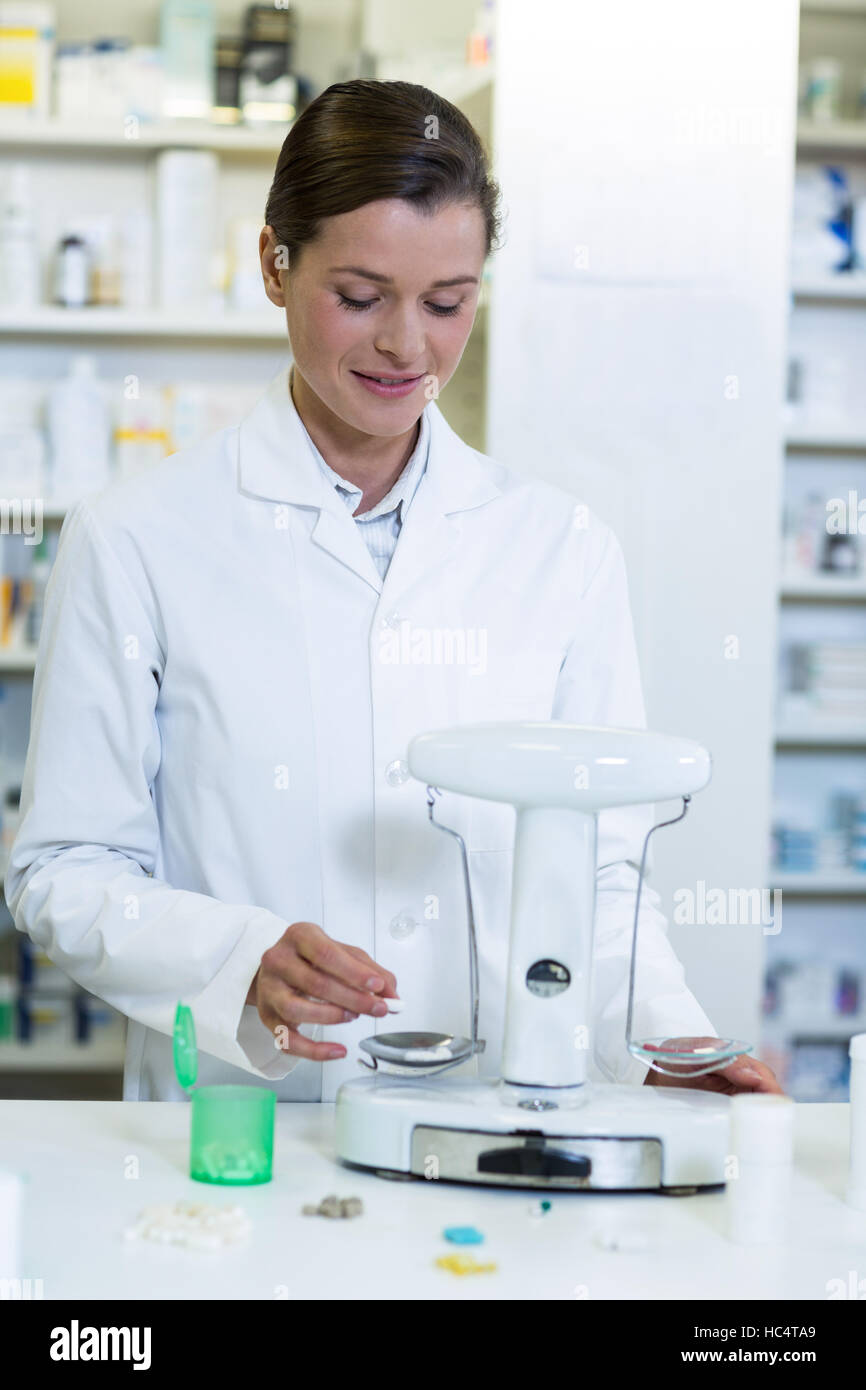 Pharmacist measuring tablets with pharmacy scale Stock Photo