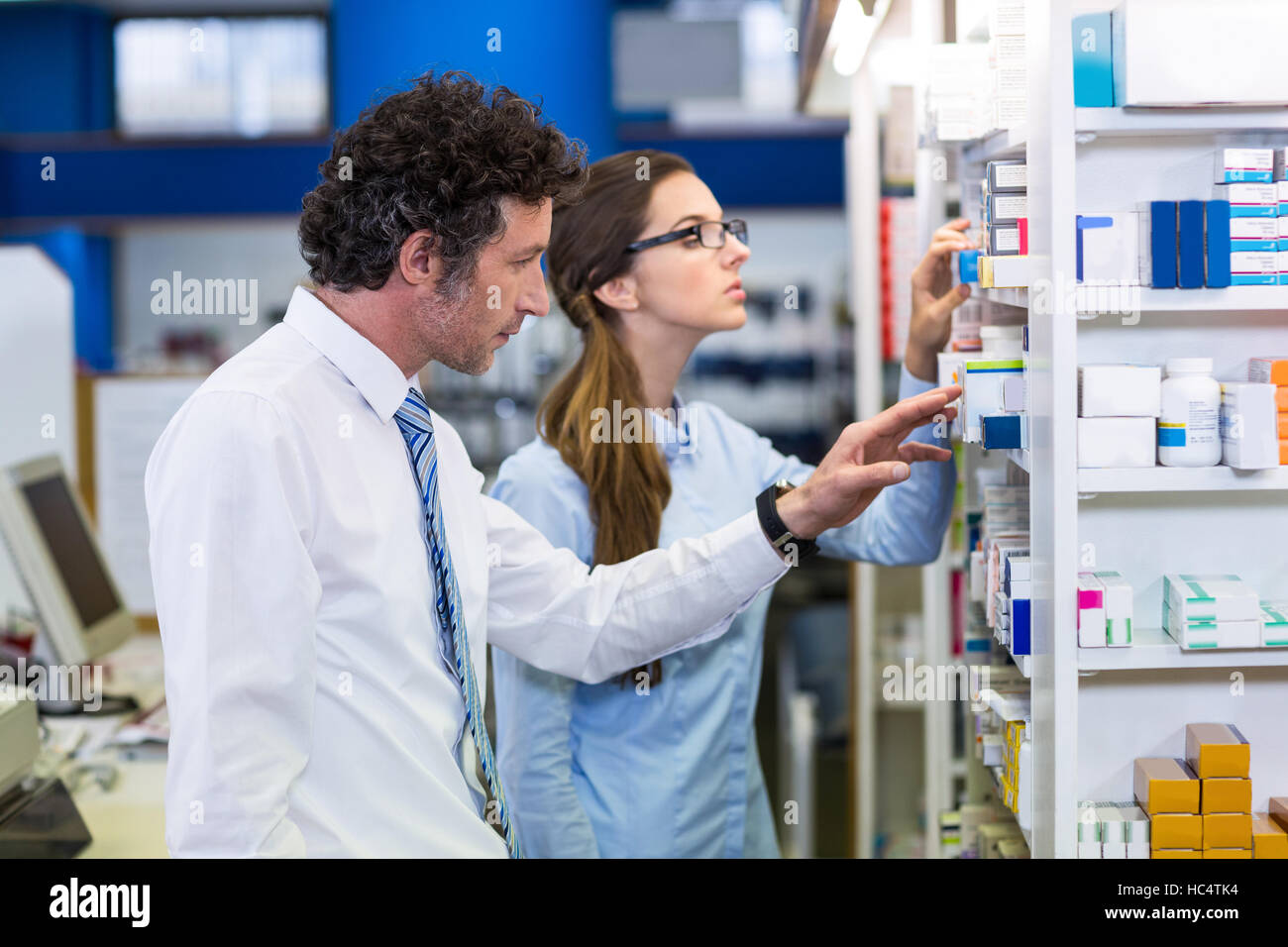 Pharmacists checking medicines on shelf in pharmacy Stock Photo Alamy