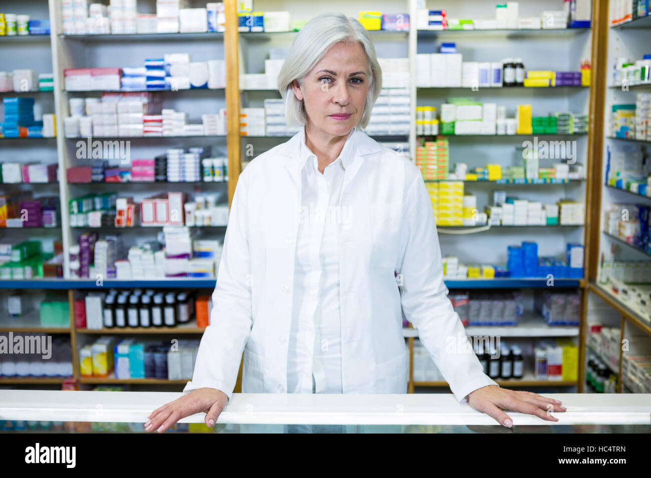 Pharmacist standing at counter Stock Photo
