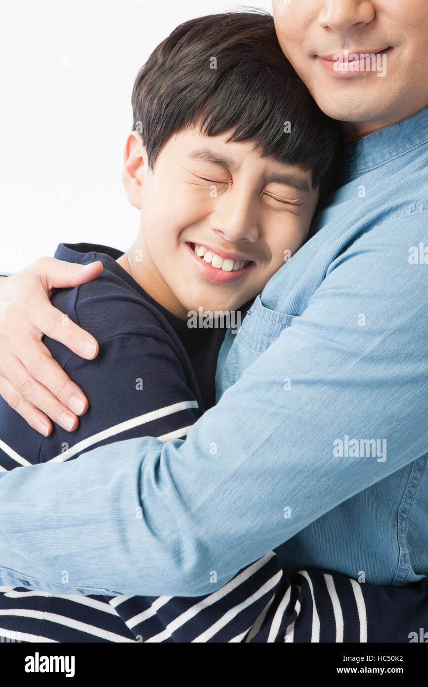 Close up of middle aged father and adolescent son hugging Stock Photo