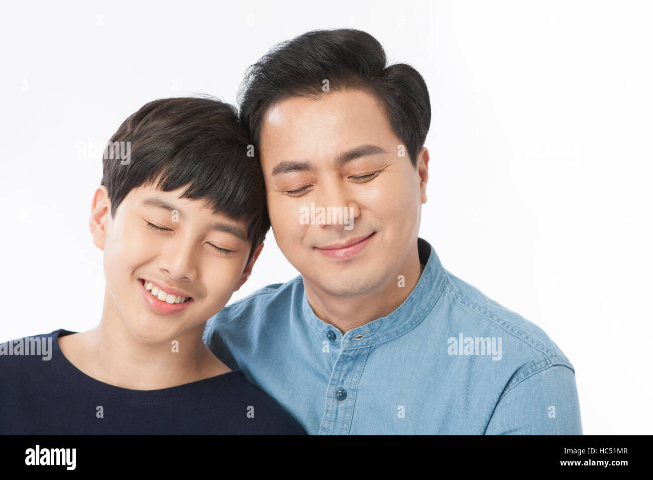 Portrait of smiling father and son face to face closing their eyes Stock Photo