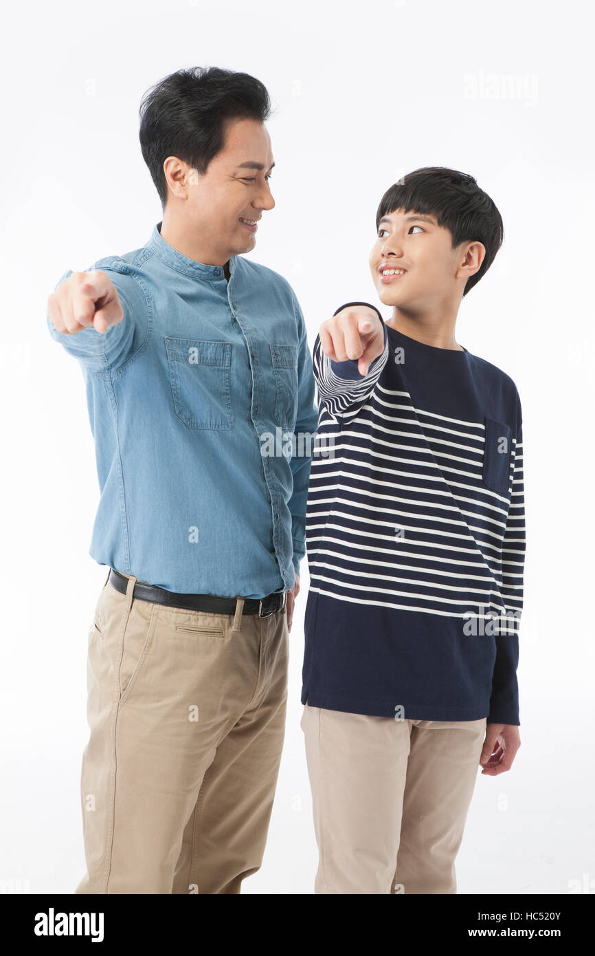 Smiling father and son pointing front together fcae to face Stock Photo