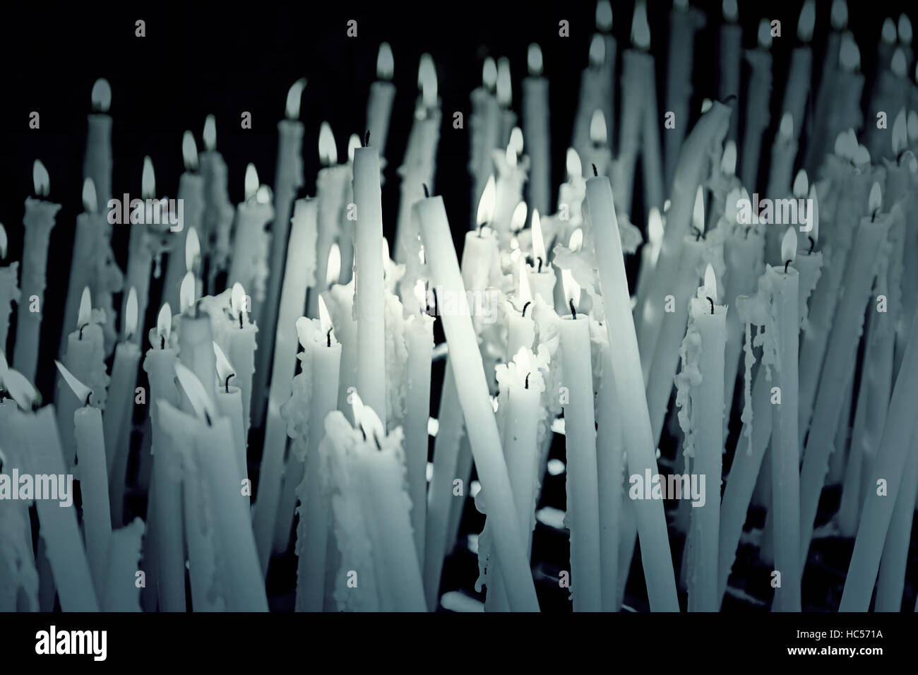 White lit candles in religious shrine, symbolism Stock Photo Alamy