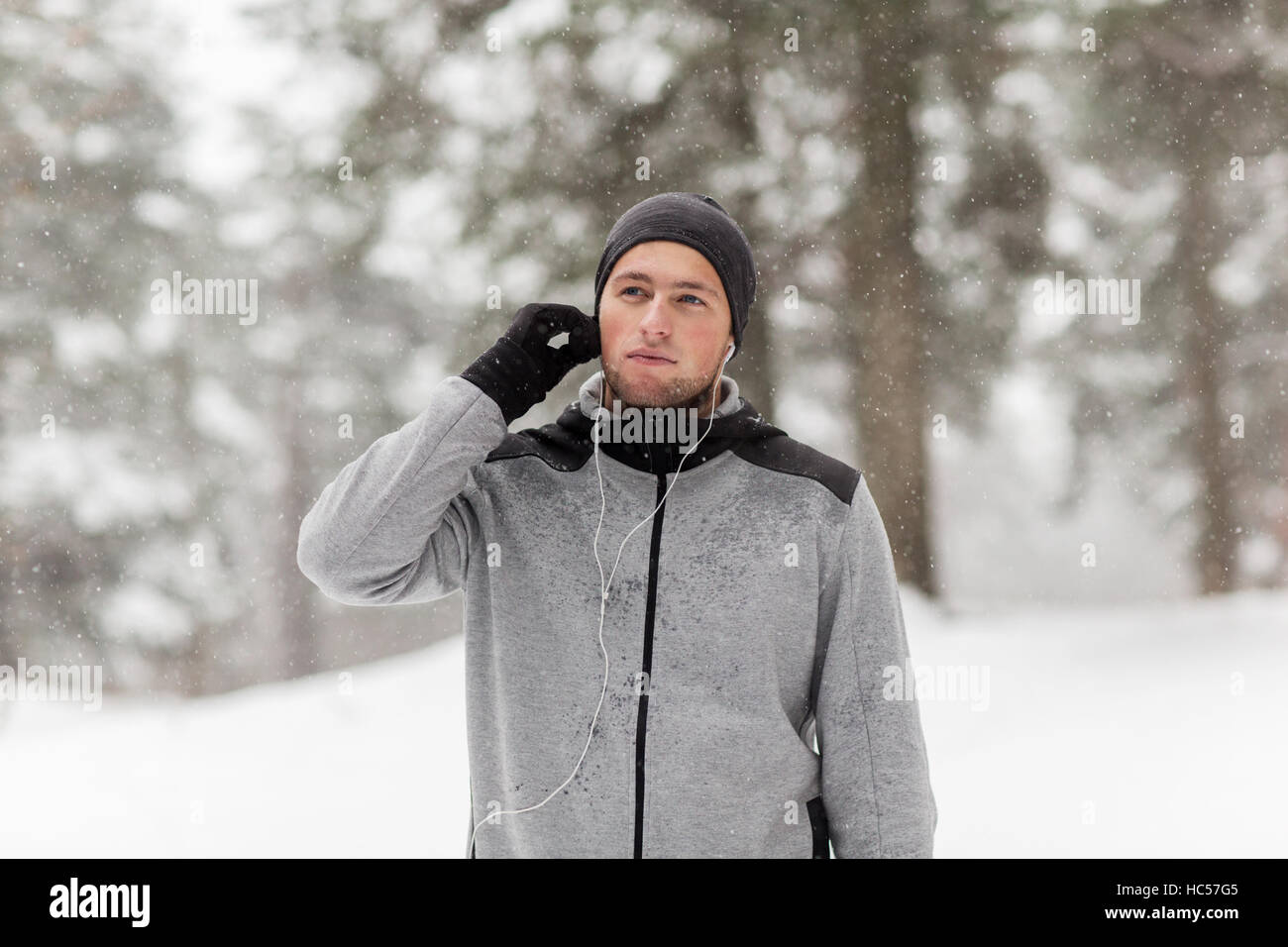 sports man with earphones in winter forest Stock Photo