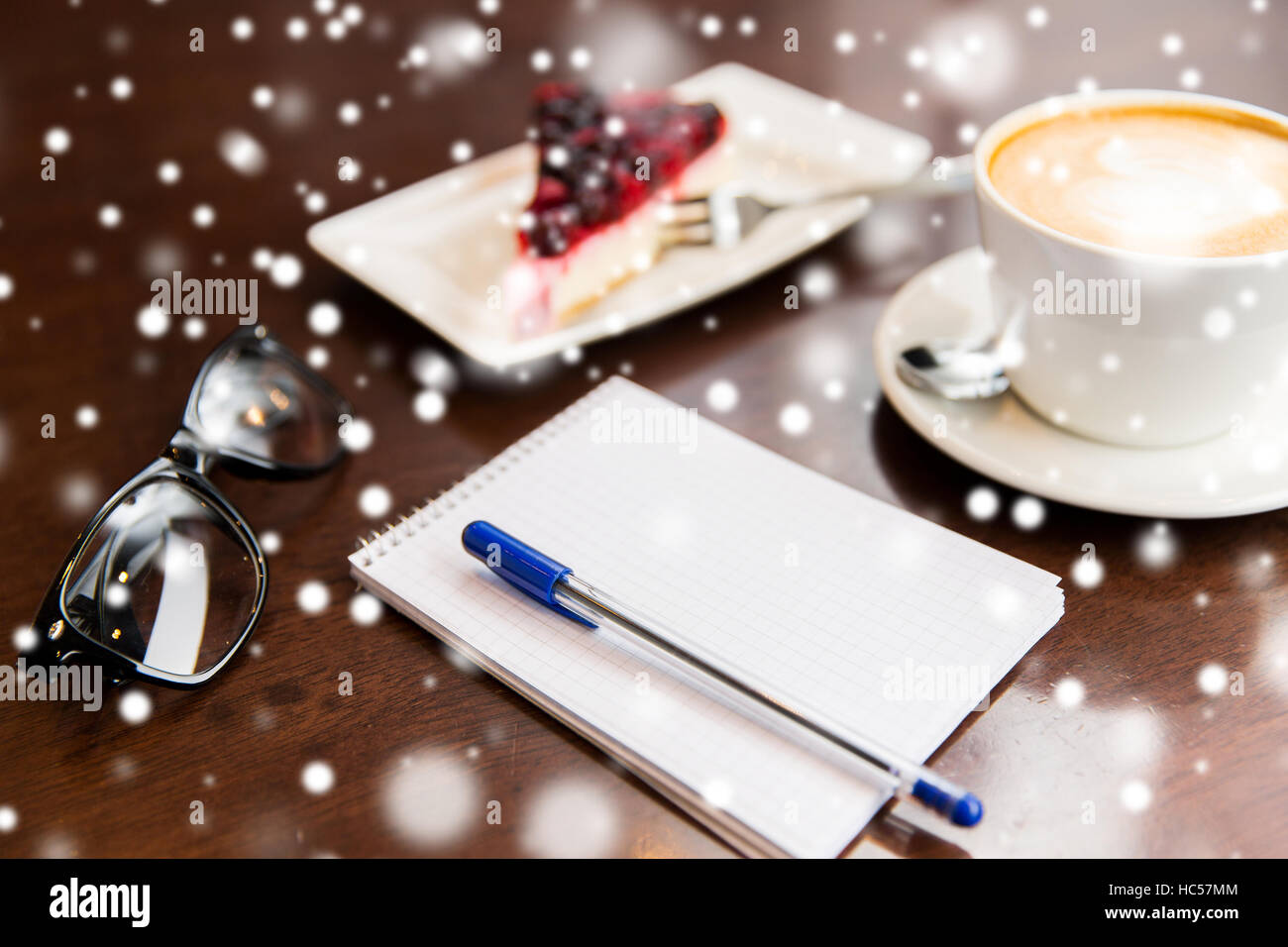 close up of notebook with pen, coffee cup and cake Stock Photo