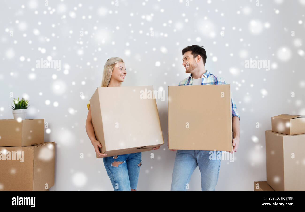 smiling couple with big boxes moving to new home Stock Photo - Alamy