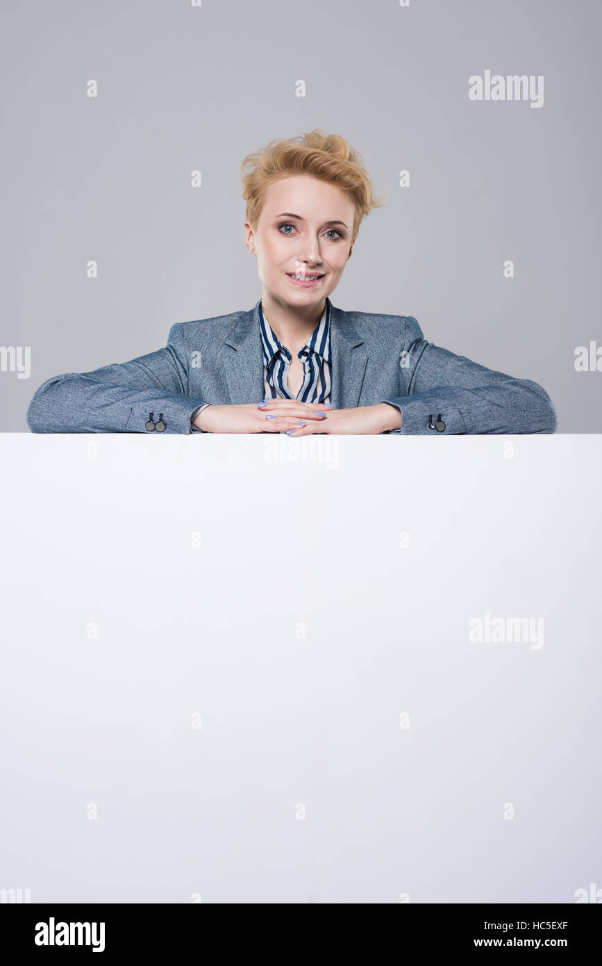 Woman leaning on a big placard Stock Photo