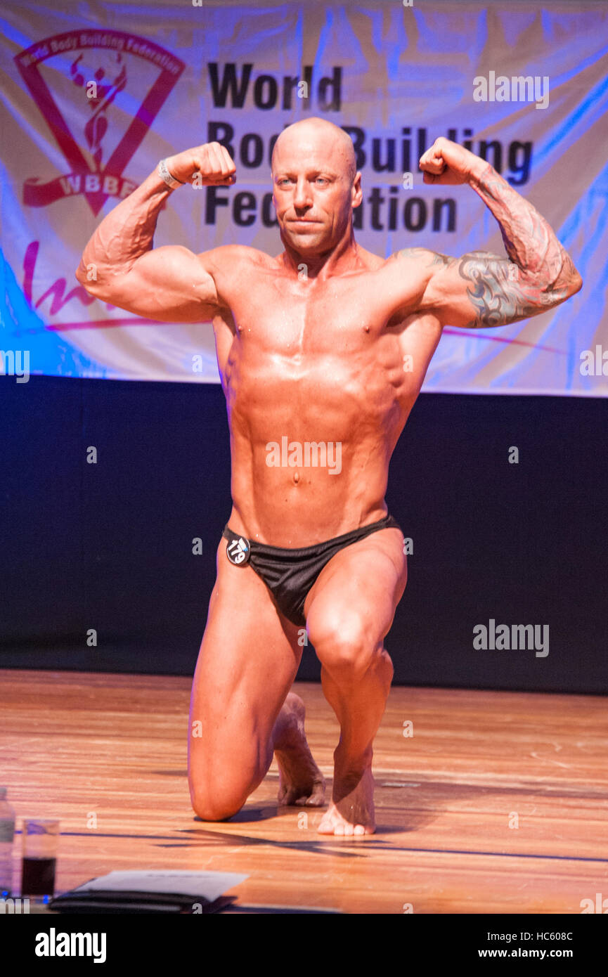 MAASTRICHT, THE NETHERLANDS - OCTOBER 25, 2015: Male bodybuilder Erik Stobbe flexes his muscles and shows his best physique in a front pose on stage Stock Photo