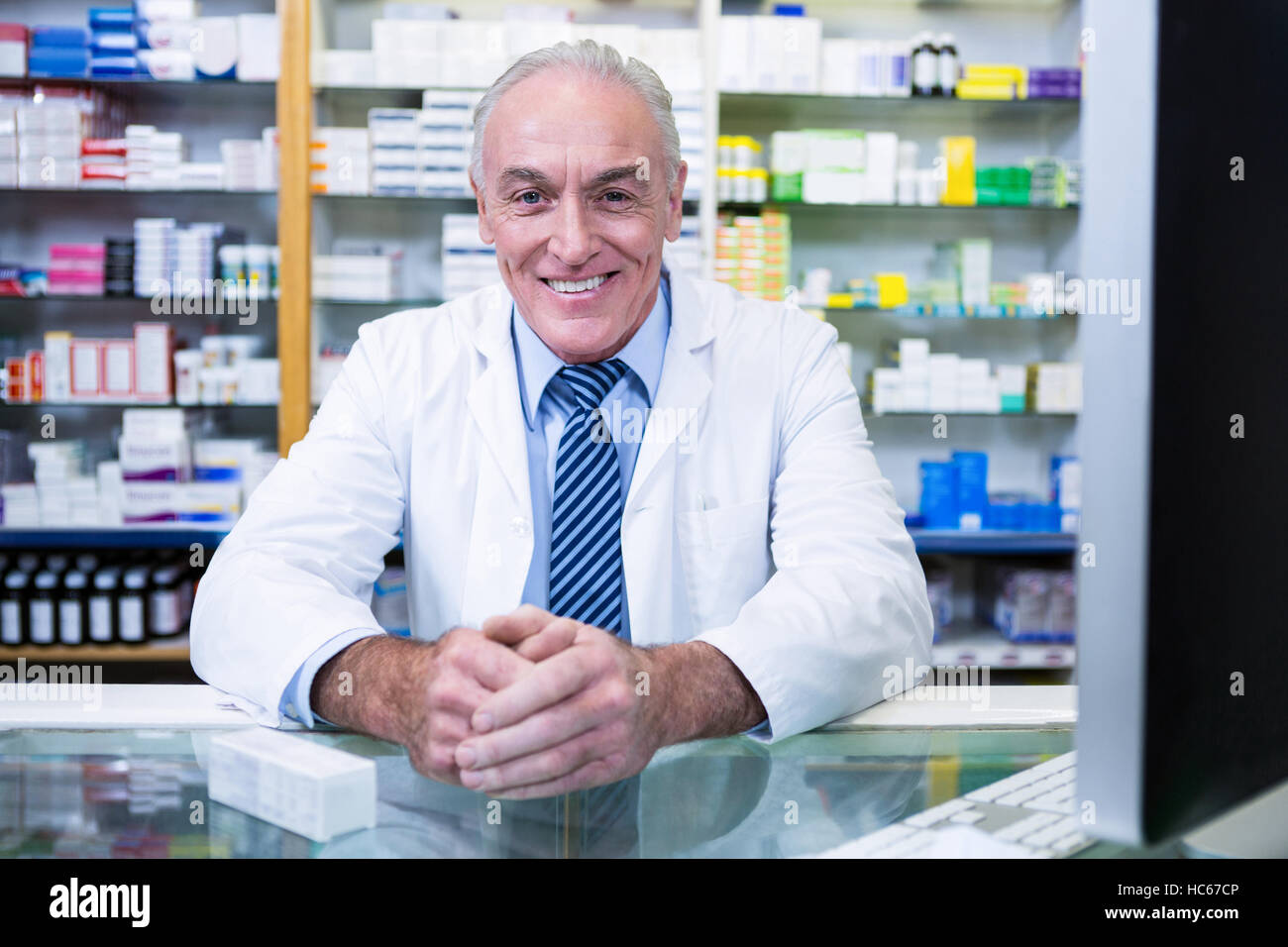 Pharmacist sitting at counter Stock Photo
