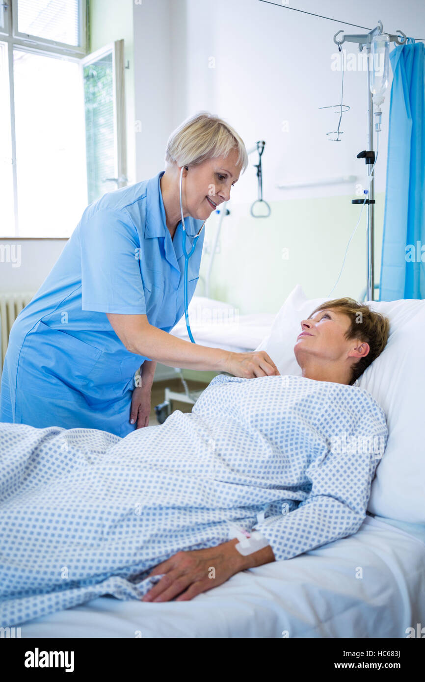 Nurse examining a patient with a stethoscope Stock Photo