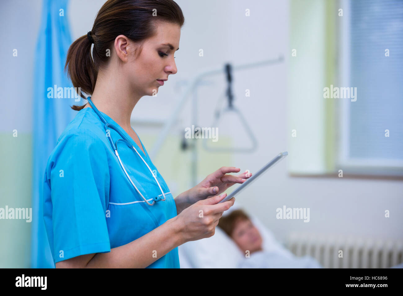 Nurse using digital tablet in hospital ward Stock Photo