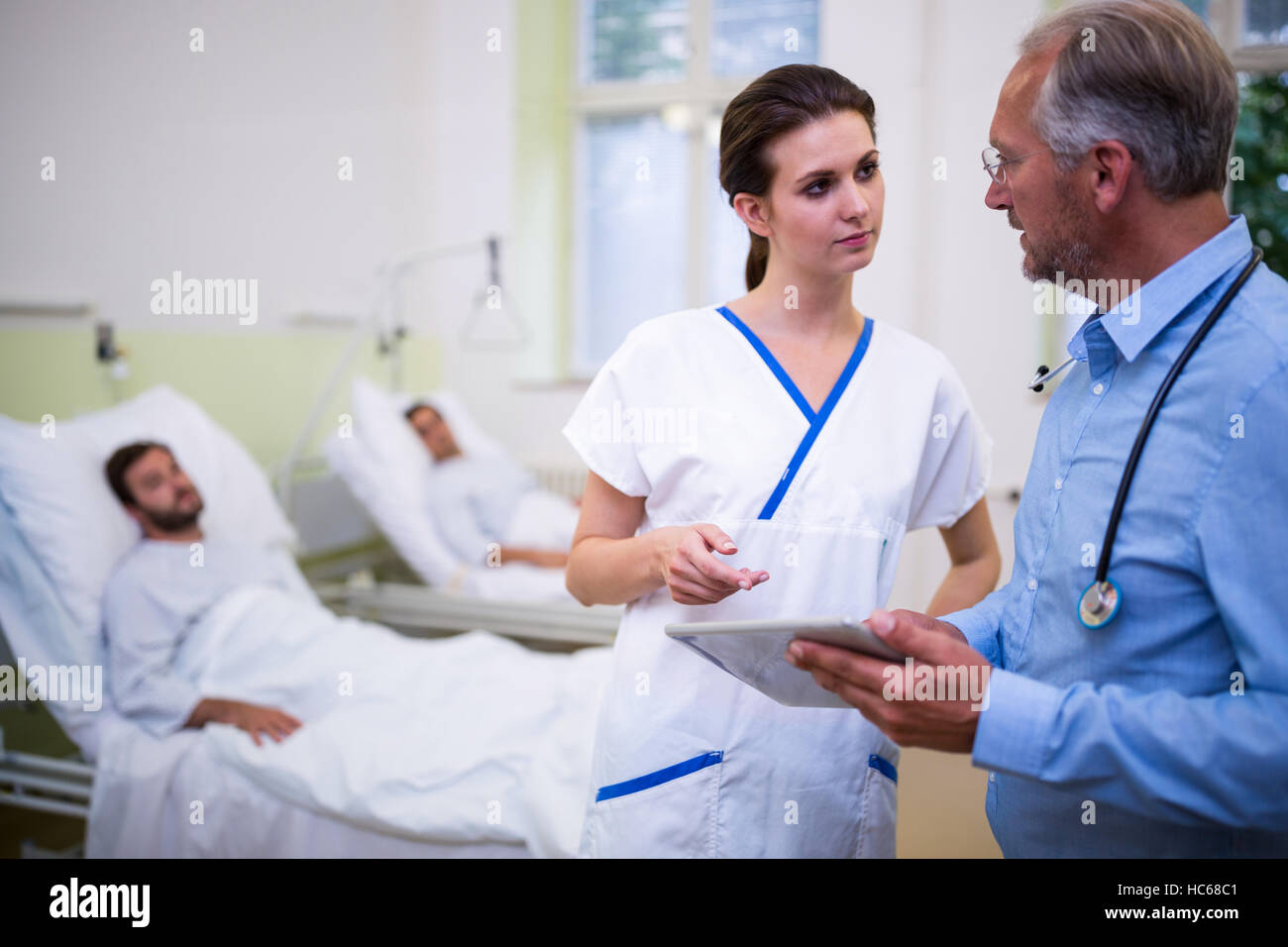 Doctor and nurse discussing over digital tablet Stock Photo - Alamy