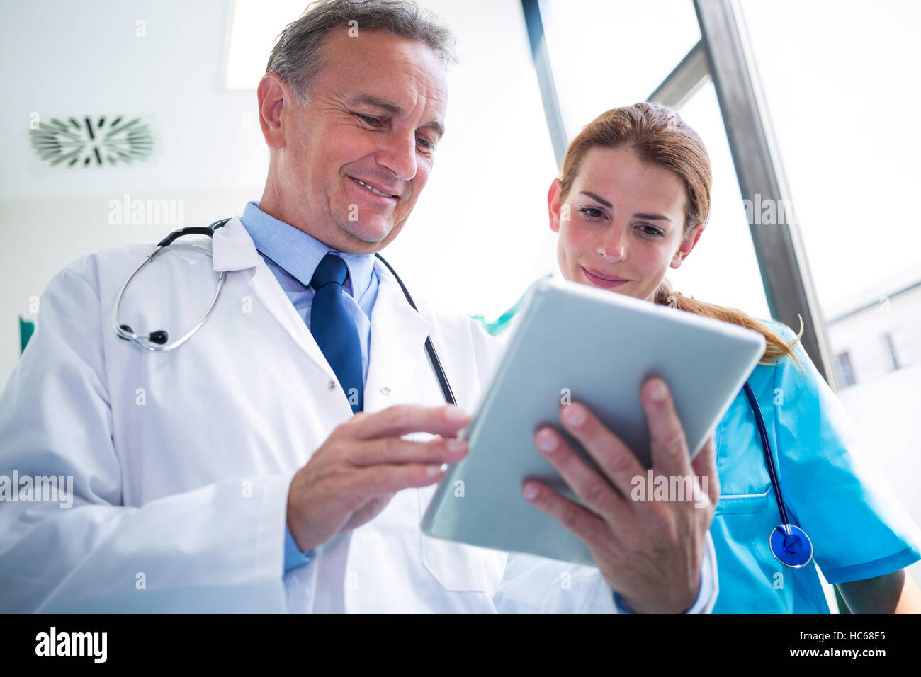 Doctor and nurse discussing over digital tablet Stock Photo - Alamy
