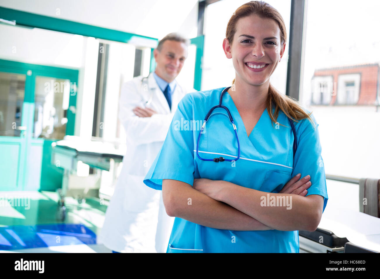 Portrait of doctor and nurse standing with arms crossed Stock Photo