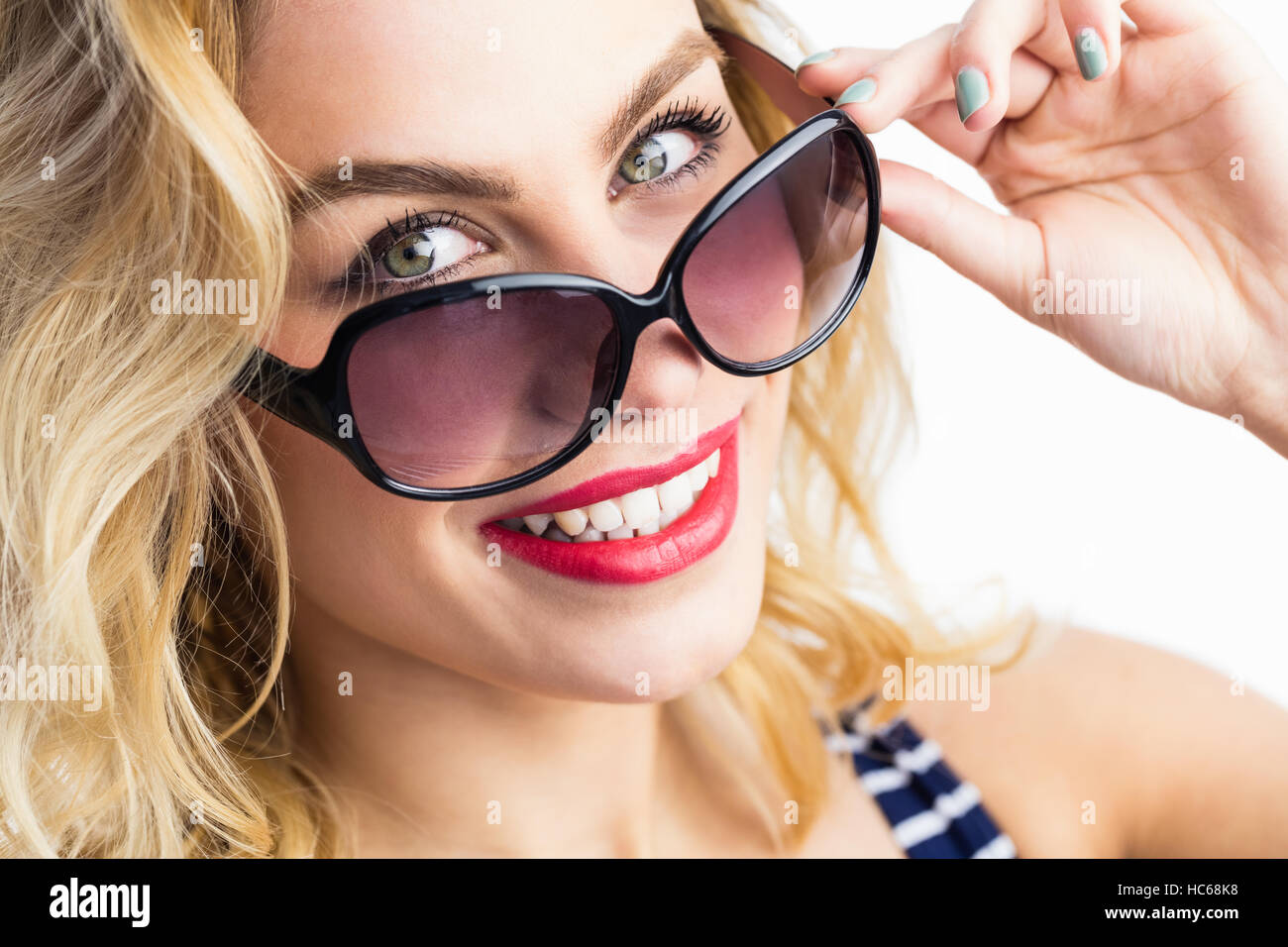 Portrait of beautiful woman posing with sunglasses against white background Stock Photo