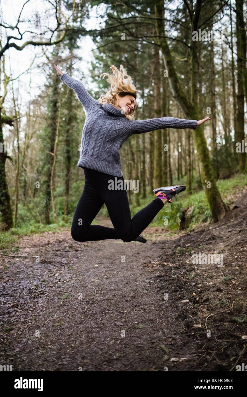 Beautiful woman jumping in forest Stock Photo
