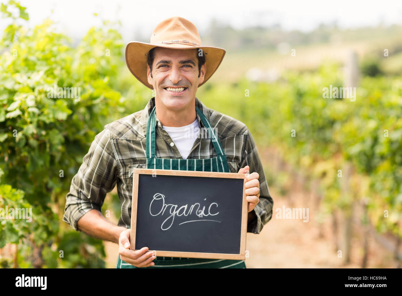 Portrait of smiling farmer holding an organic sign Stock Photo - Alamy