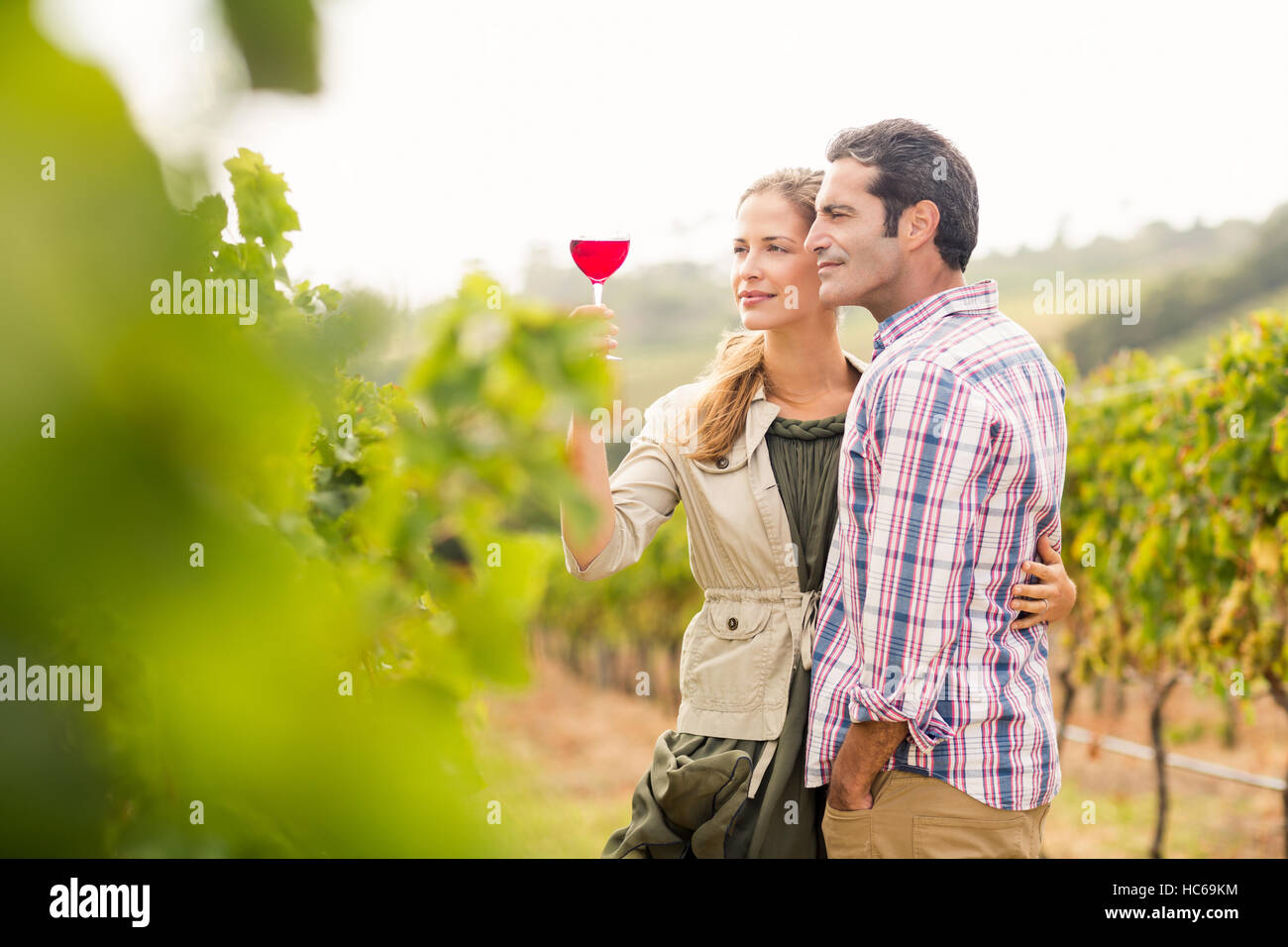 Happy couple looking at glass of wine Stock Photo - Alamy
