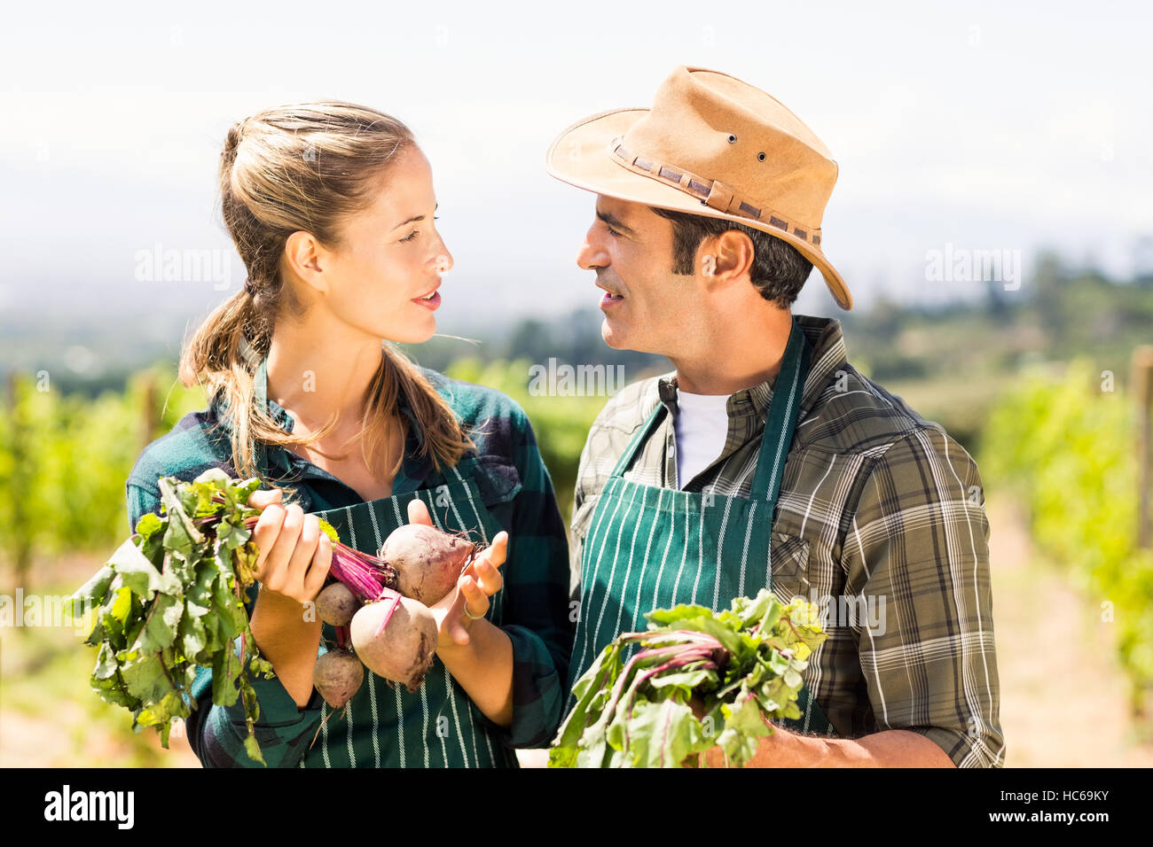 Happy farmer couple holding leafy vegetables Stock Photo - Alamy