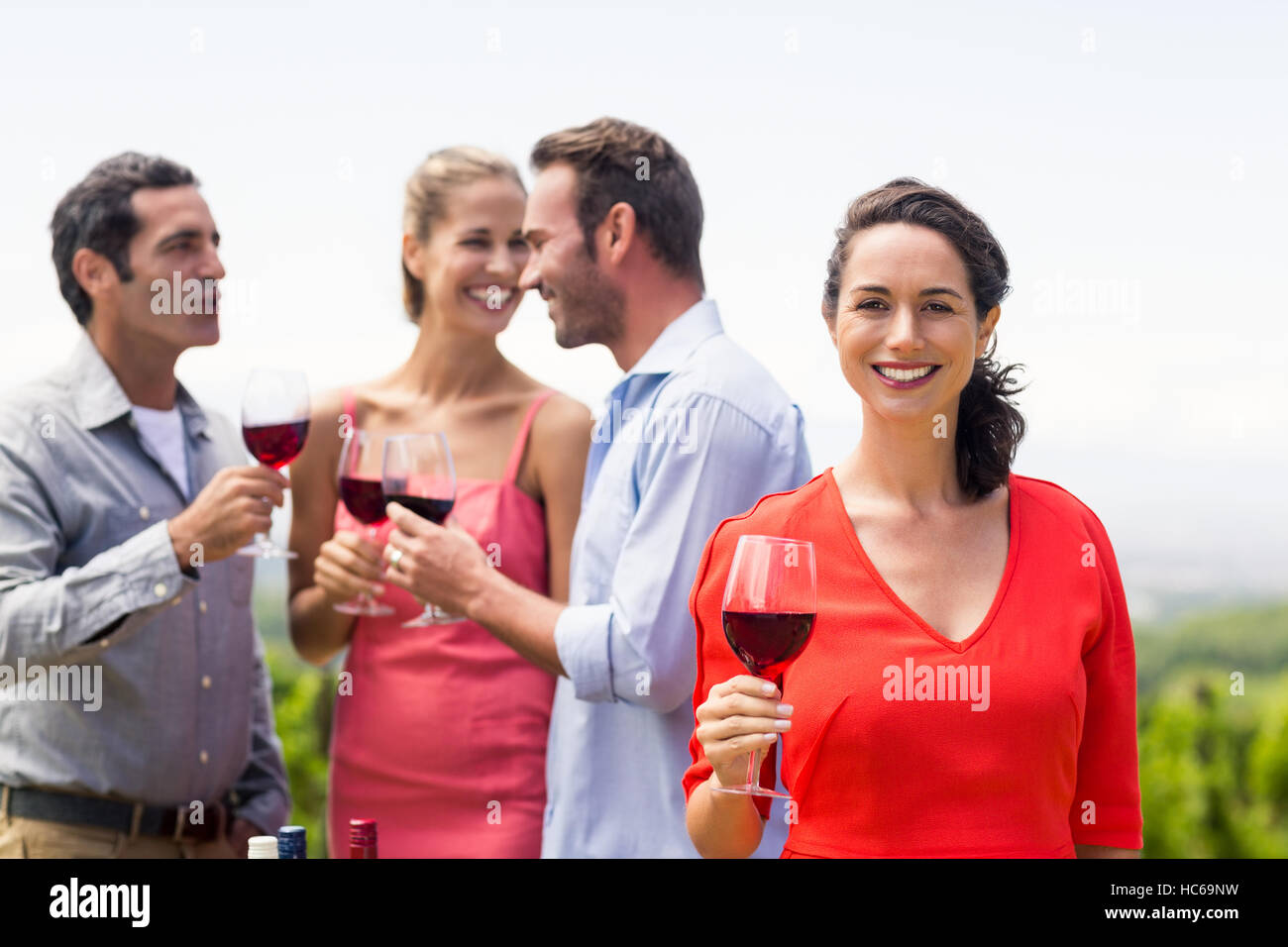 Woman holding wine glass smiling at camera Stock Photo - Alamy