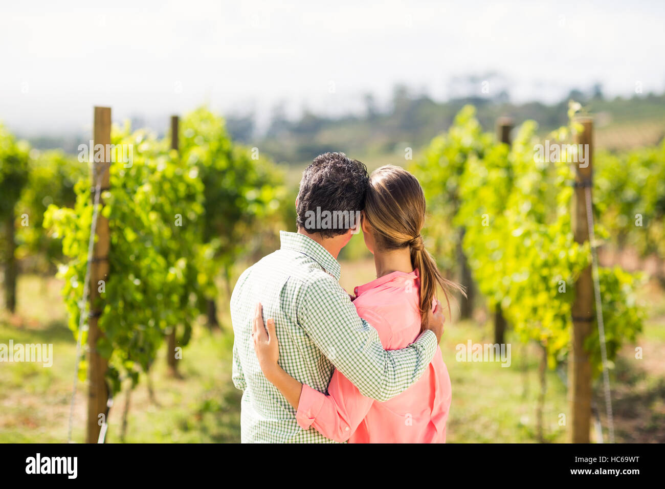 Couple standing with arm around and looking at nature Stock Photo