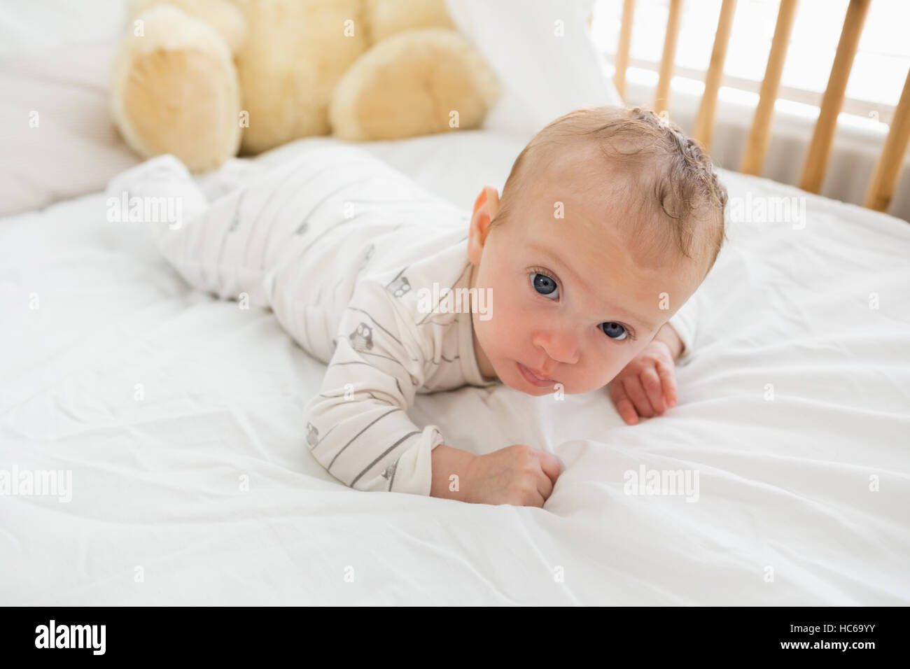 Baby lying on baby bed Stock Photo