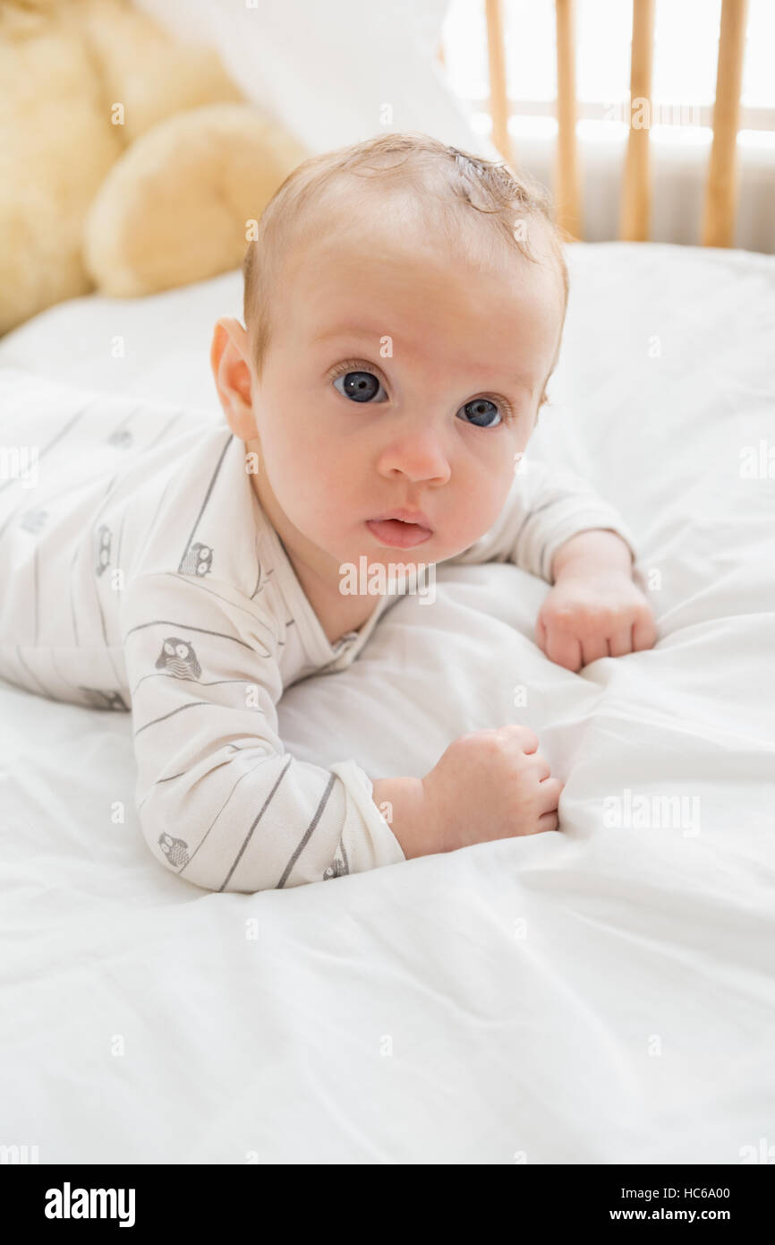Baby lying on baby bed Stock Photo Alamy