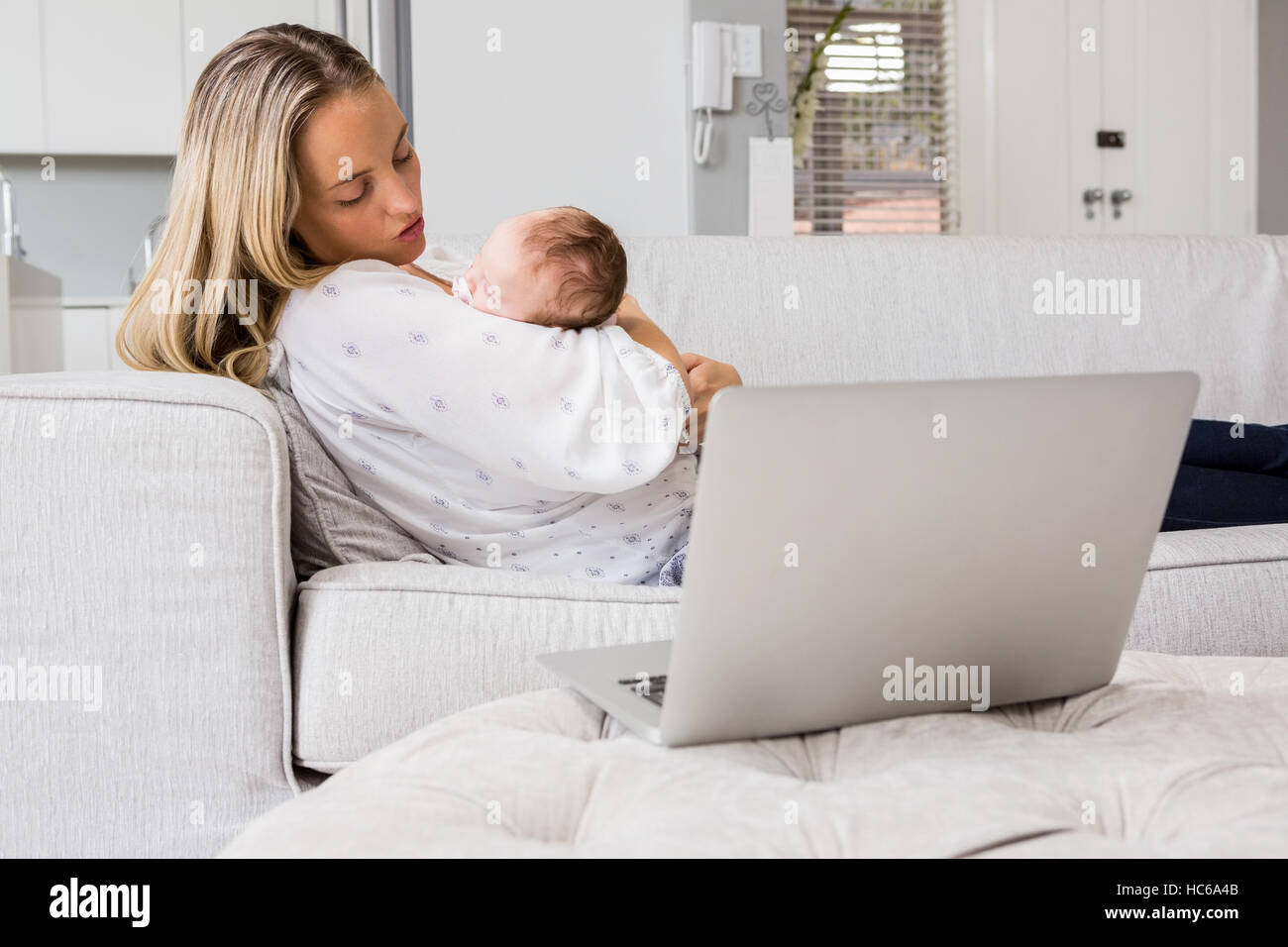 Mother consoling her baby in living room Stock Photo