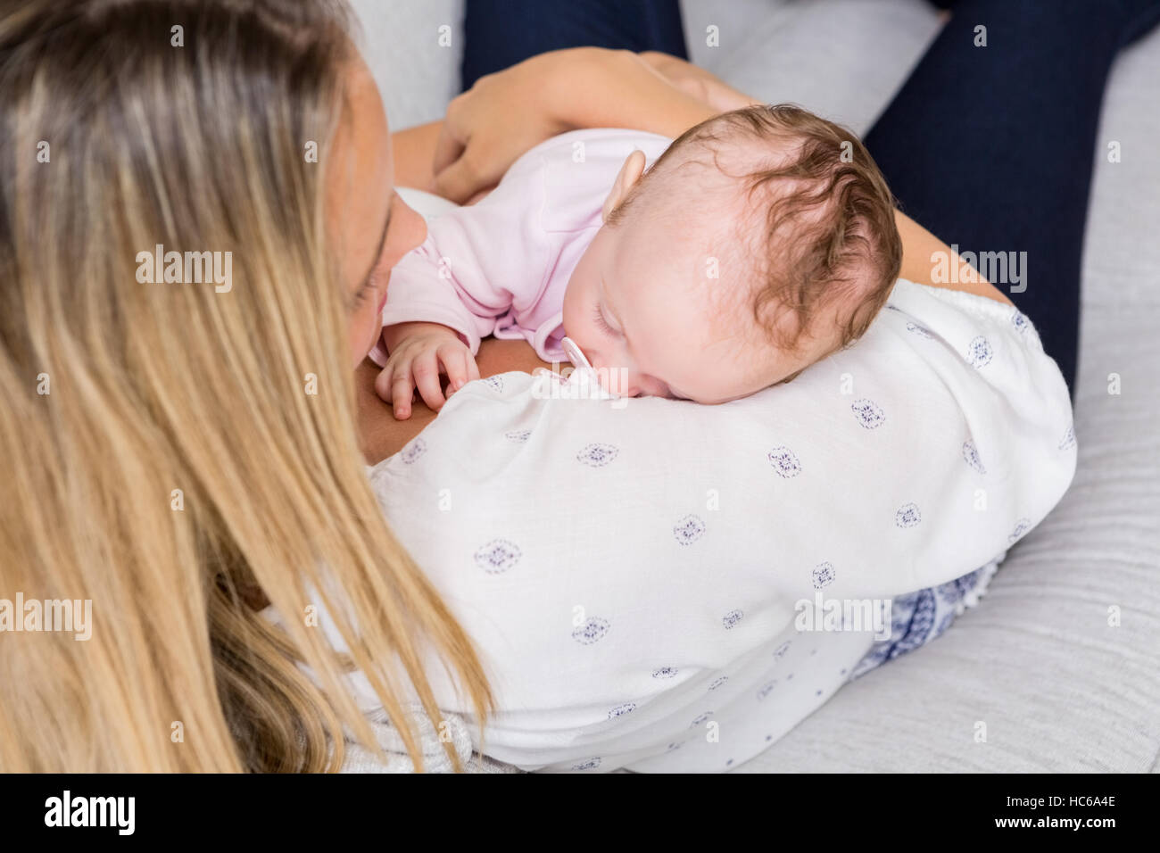 Mother carrying her baby in living room Stock Photo