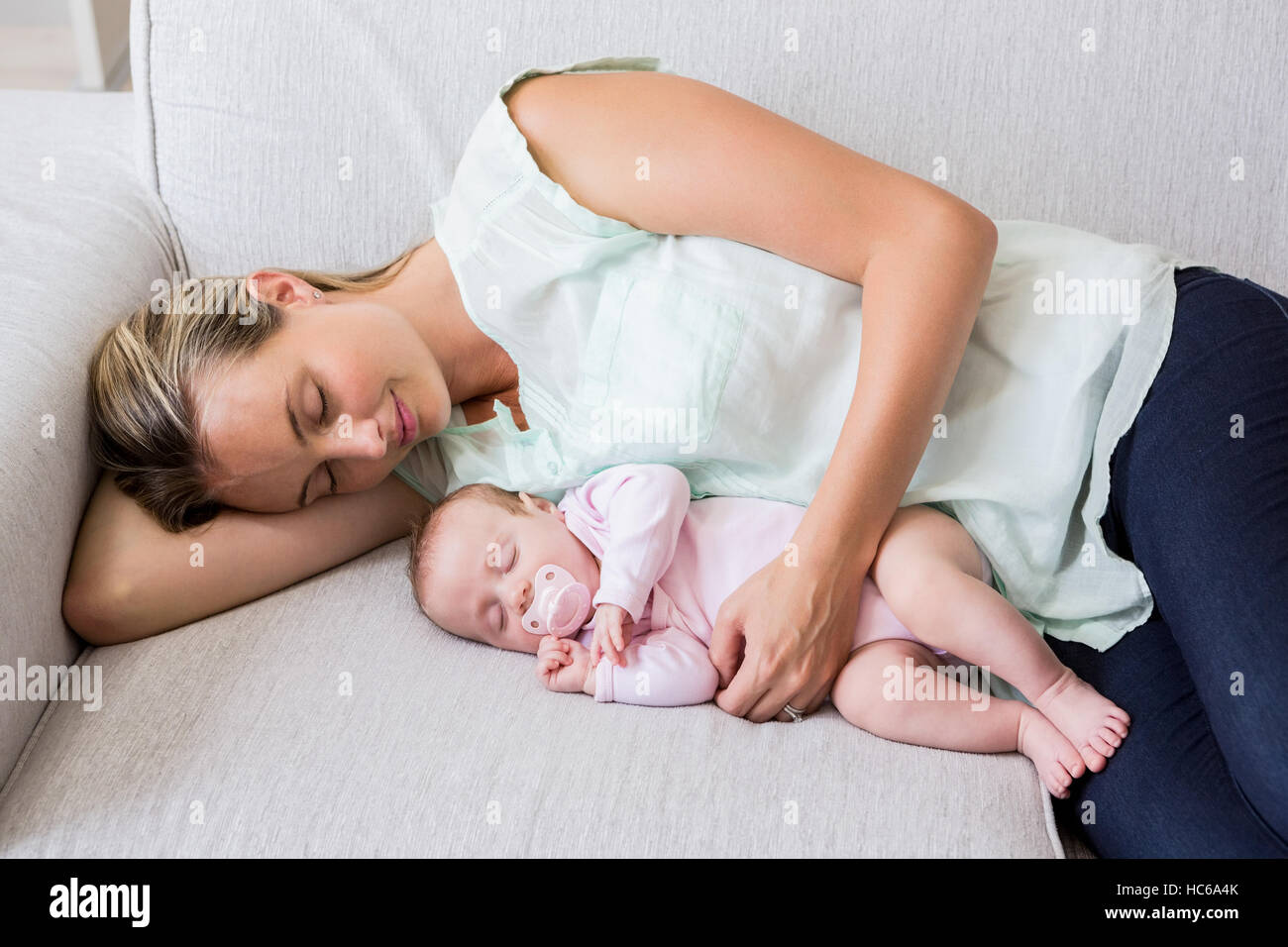 Mother sleeping with her baby in living room Stock Photo Alamy