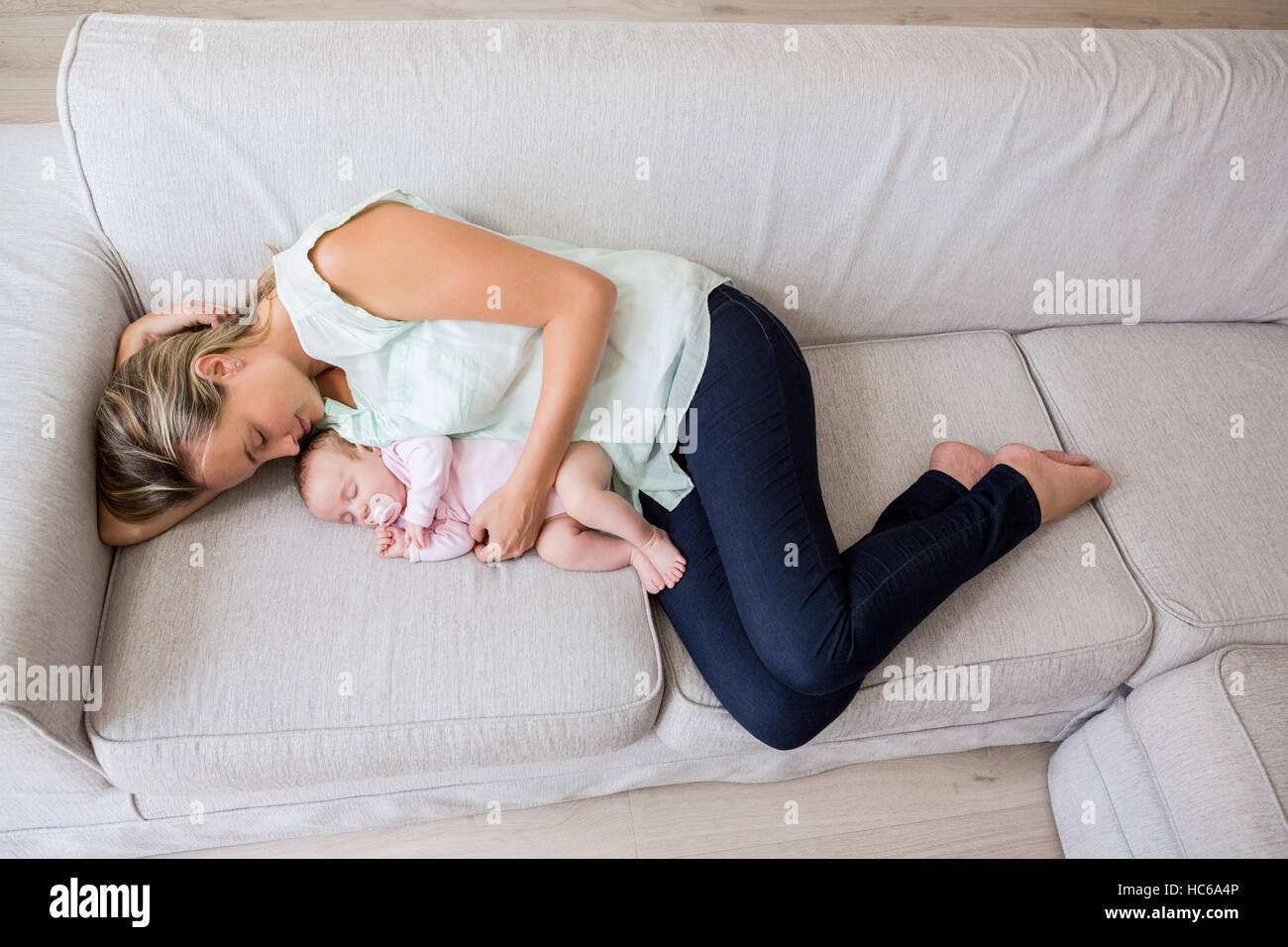 Mother sleeping with her baby in living room Stock Photo Alamy