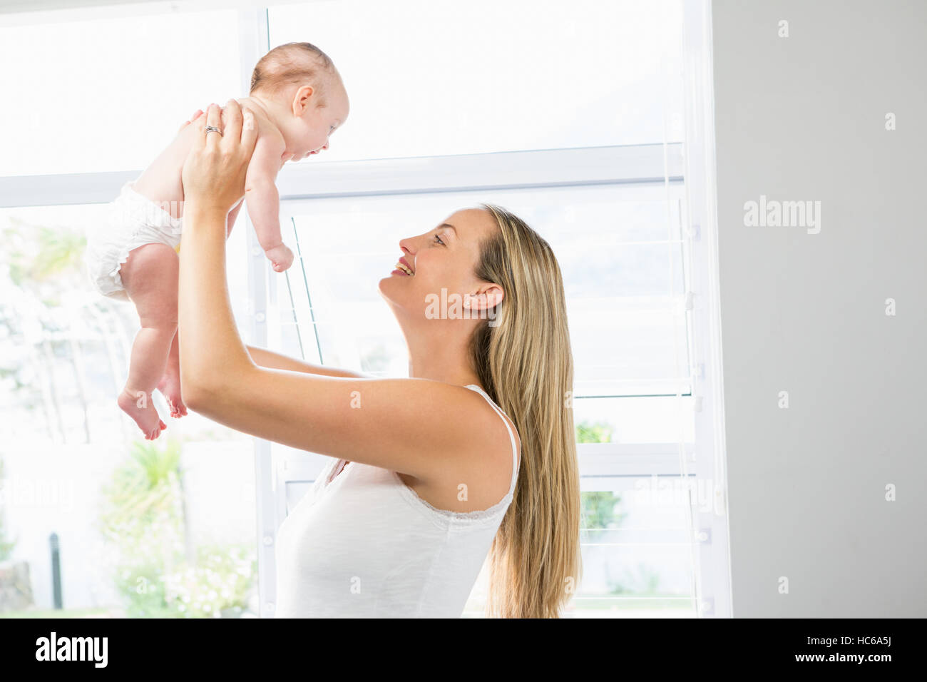 Mother playing with her baby in living room Stock Photo