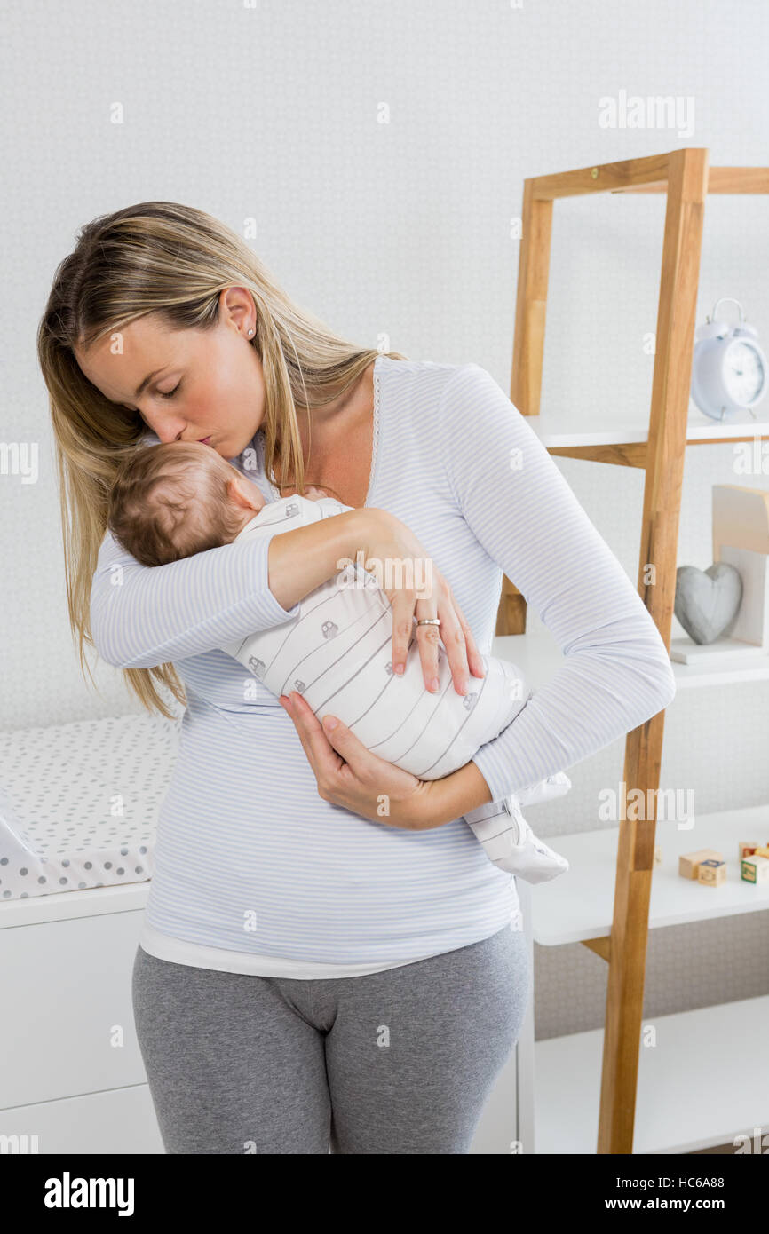 Mother holding and kissing her baby boy Stock Photo
