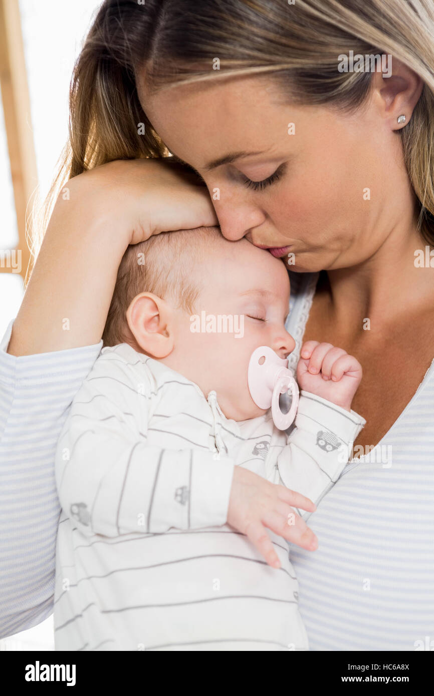 Mother holding and kissing her baby boy Stock Photo