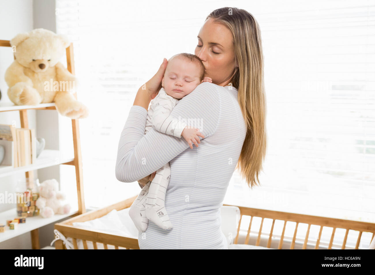 Mother holding and kissing her baby boy Stock Photo