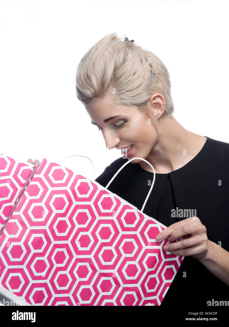 A attractive blonde haired woman is looking into her shopping bag smiling. Stock Photo