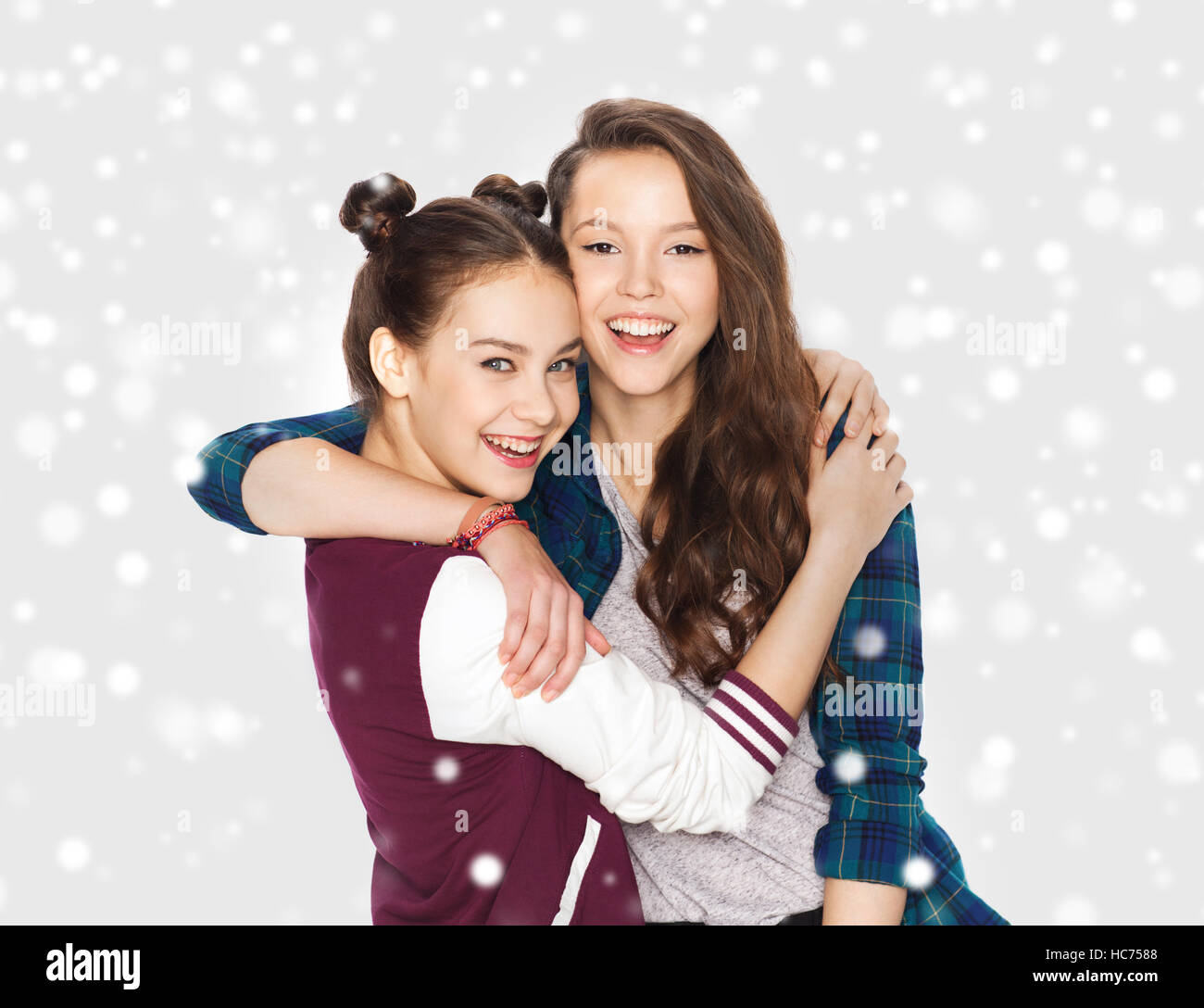 happy pretty teenage girls hugging over snow Stock Photo - Alamy