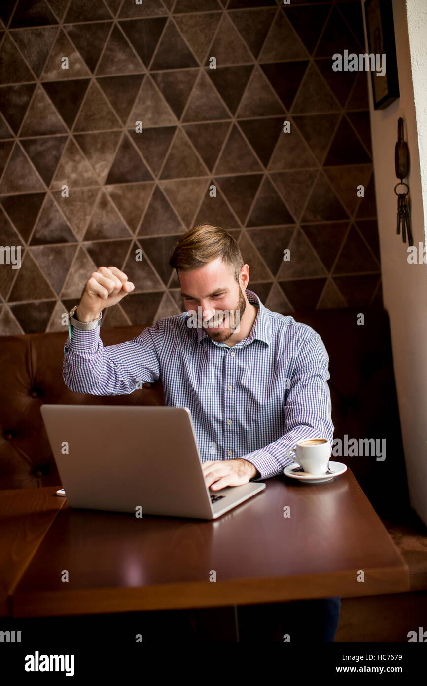 Young man uses a laptop and looking forward to something Stock Photo
