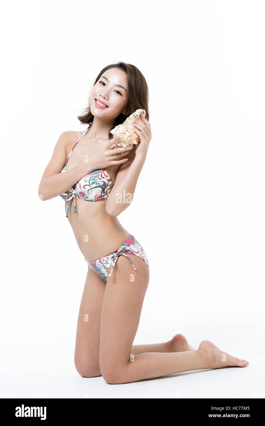 Woman in bikini with seashell posing on beach towel Stock Photo Alamy