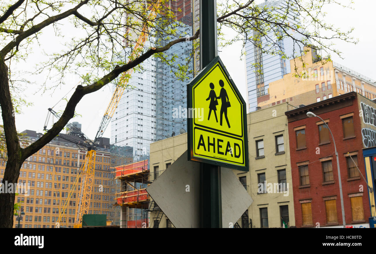 yellow traffic sign in New York of school zone with crossing children with the word ahead Stock Photo