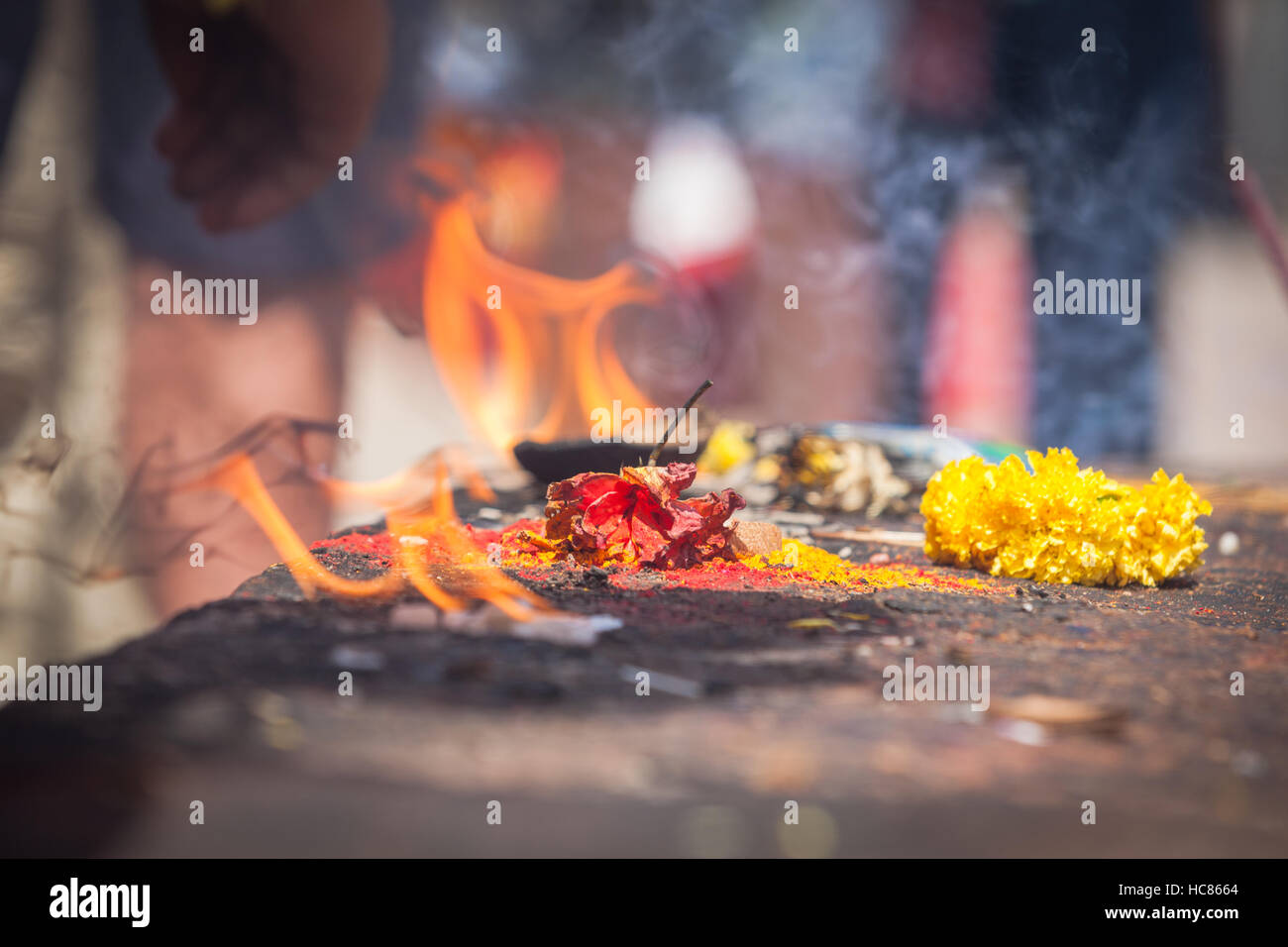 Hindu religious ceremony, near Hospet, India, where flowers and paper is burned before entering the temple nearby. Stock Photo