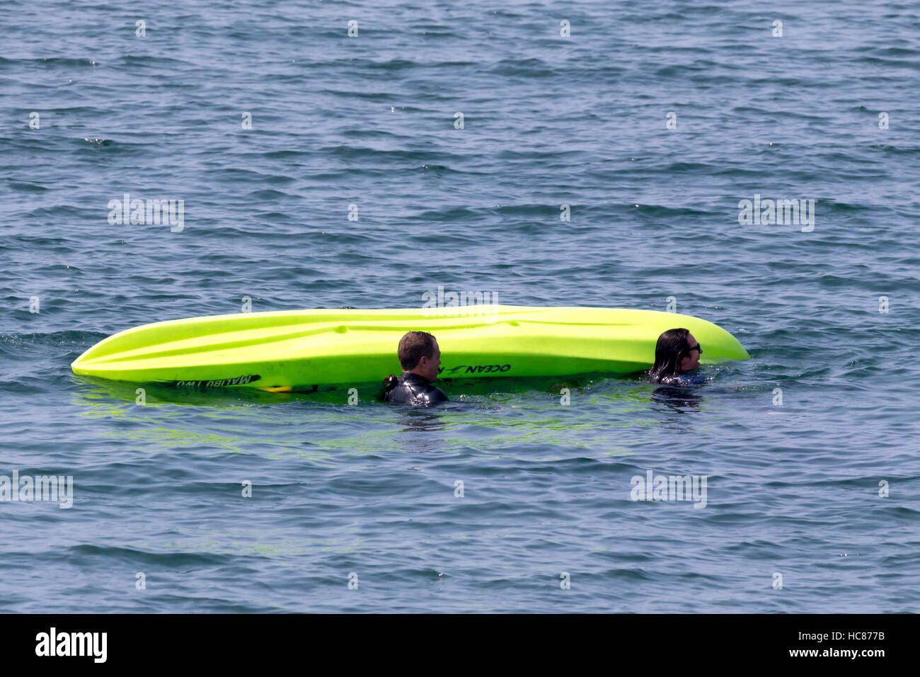 A capsized kayak with two people in the sea Stock Photo Alamy