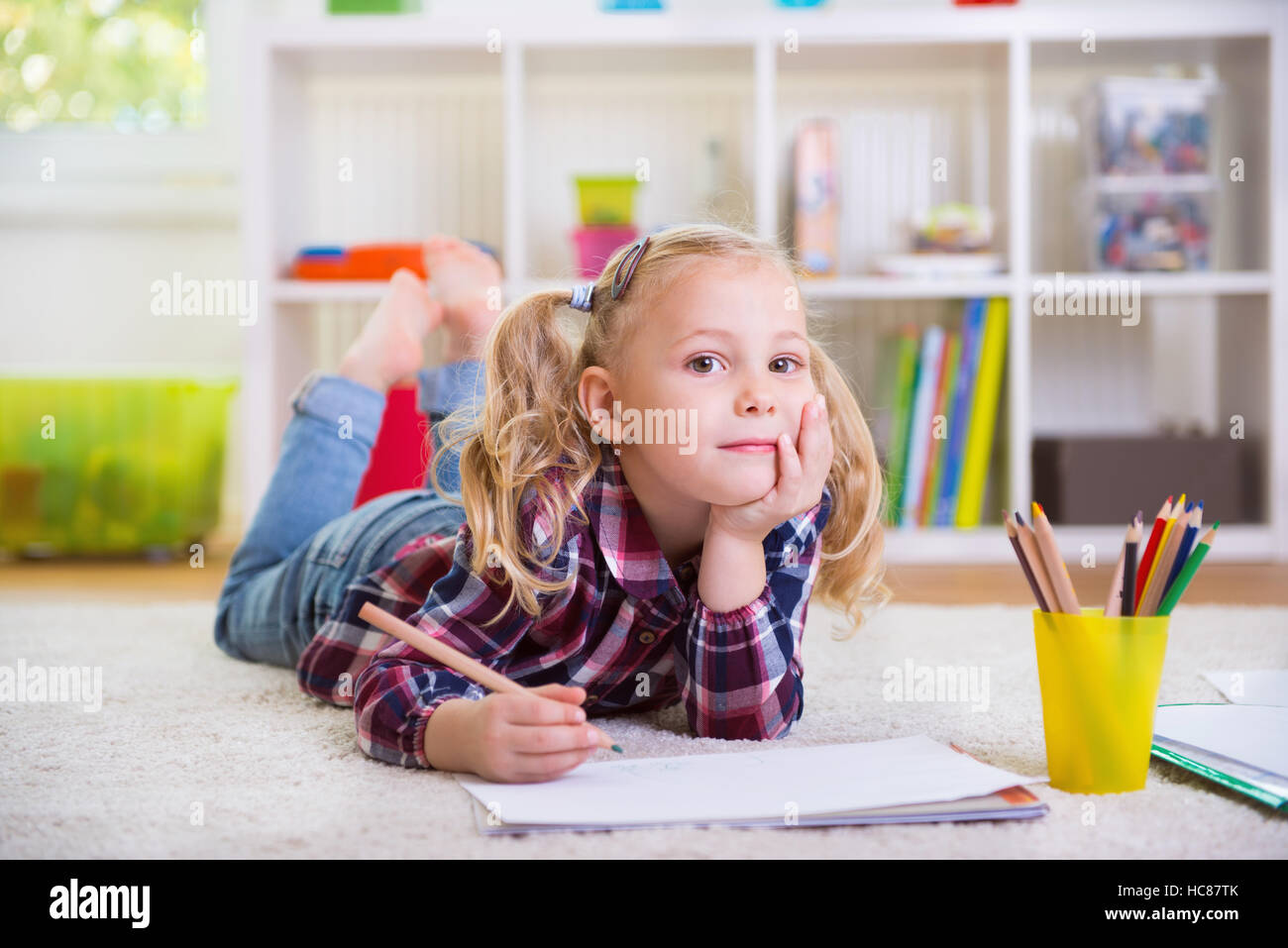 Cute little girl laying on floor at home Stock Photo - Alamy