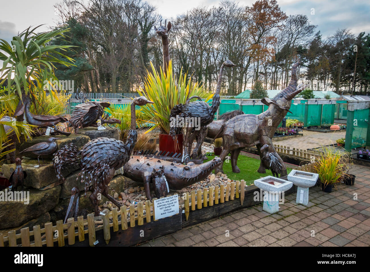 A collection of garden ornaments large steel giraffes crocodiles and ostriches statues in a suburban garden centre Stock Photo