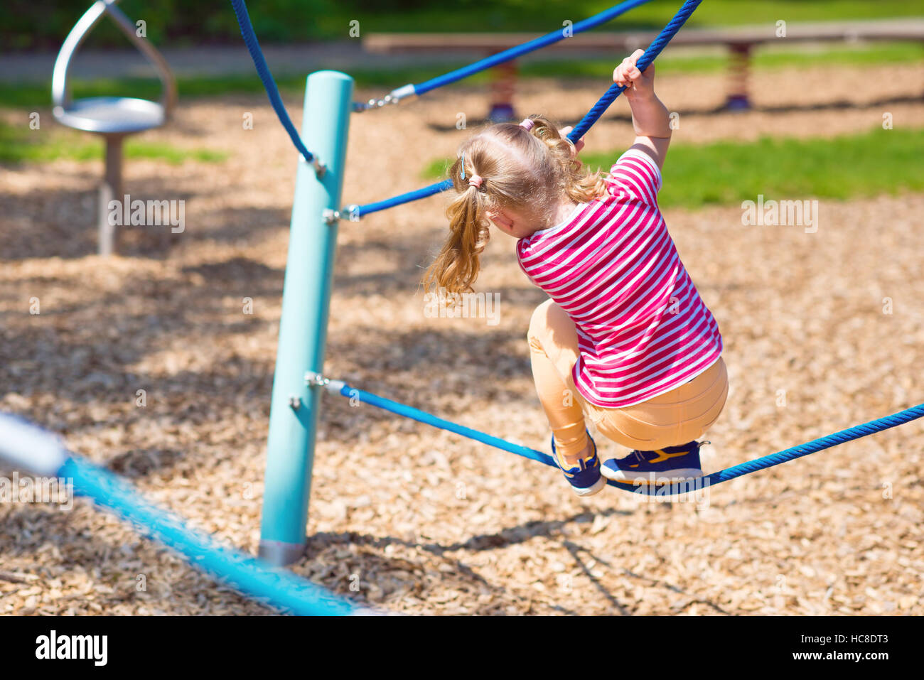 Happy little girl playing at playground in summer day Stock Photo - Alamy