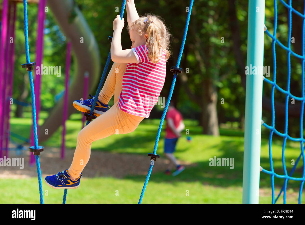 Happy little girl playing at playground in summer day Stock Photo - Alamy