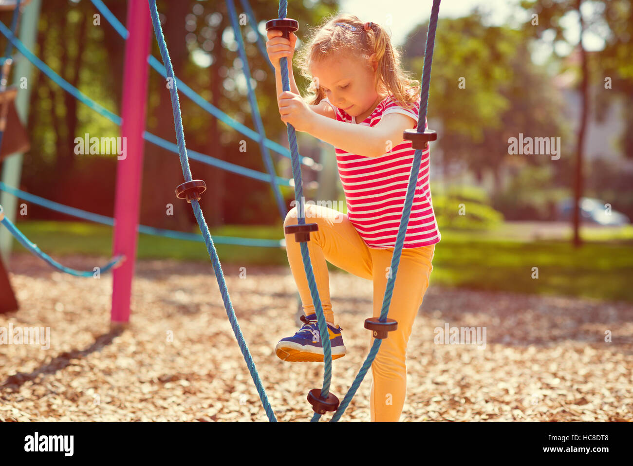 Happy little girl playing at playground in summer day Stock Photo - Alamy