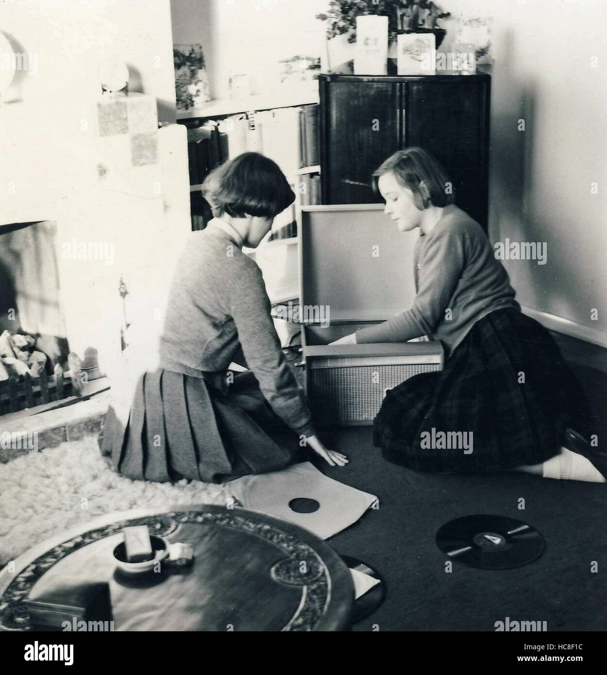 Historic archive image of two young women listening to records on a record player. c1960s Stock Photo