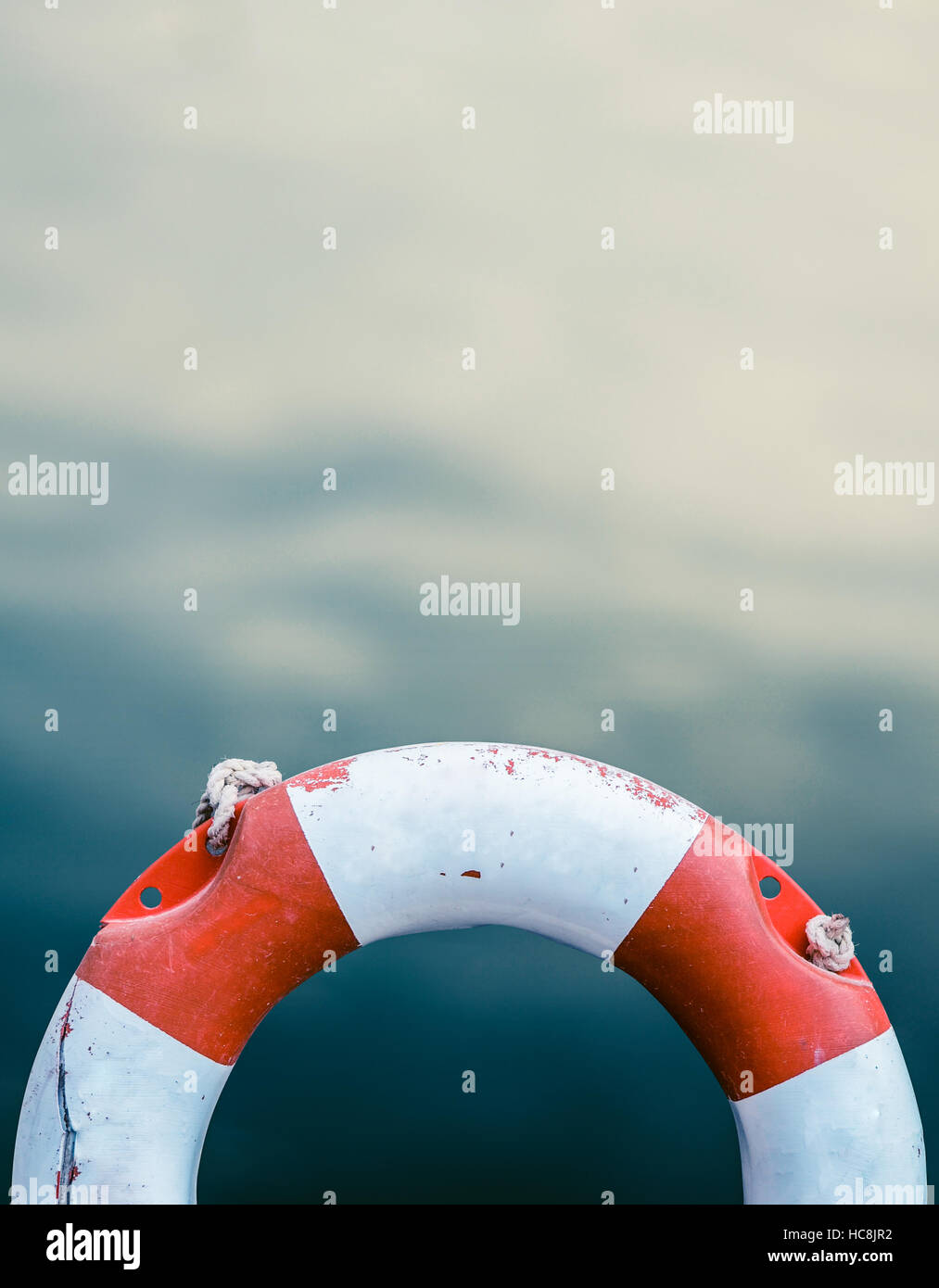 Grungy Lifebuoy Against A Calm Ocean Water Stock Photo