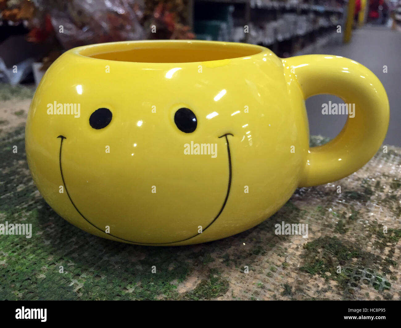 Yellow smiley-face coffee mug Stock Photo